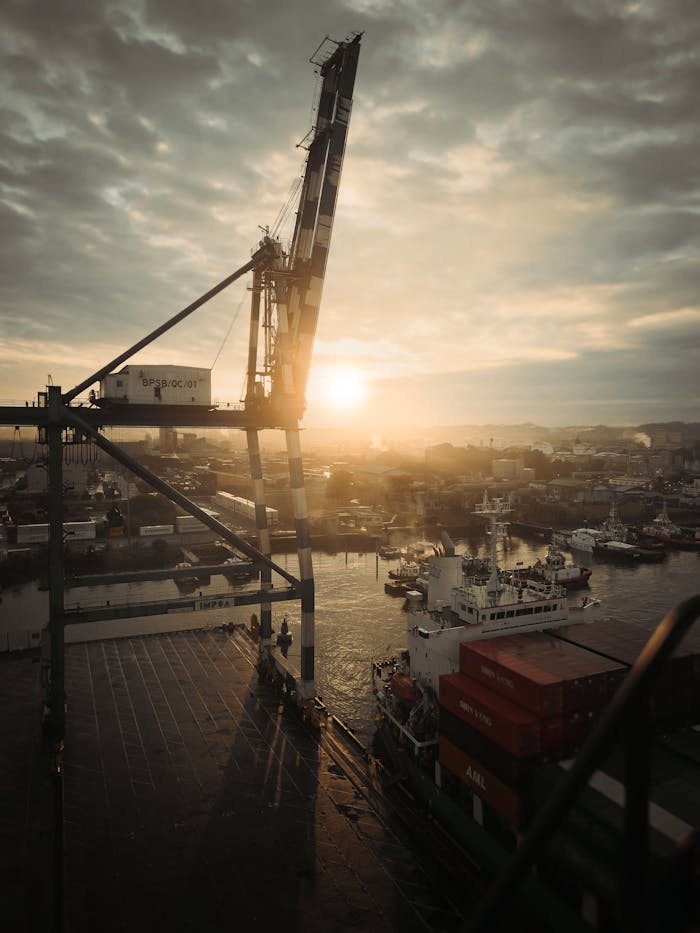 A breathtaking sunset view over Bintulu Port, Sarawak, Malaysia, featuring a crane and cargo ships.